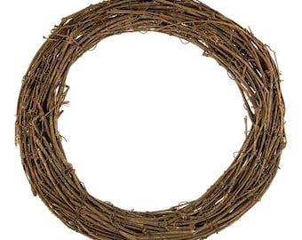 Pode incluir: Uma guirlanda circular construída com galhos naturais castanhos entrelaçados e arame fino escuro. A estrutura apresenta uma disposição densa e em camadas de ramos lenhosos que formam um centro oco, criando uma moldura arredondada e texturizada.