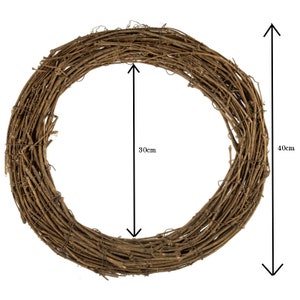 Pu&ograve; includere: Una ghirlanda circolare costruita con ramoscelli e rami naturali intrecciati di colore marrone. La ghirlanda presenta un'apertura centrale di 30 cm di diametro e un diametro esterno totale di 40 cm, come indicato dalle frecce di misurazione.