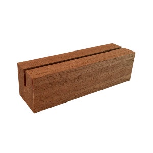 May include: A wooden sign holder with a slot for displaying a card or sign. The holder is made of dark brown wood with a natural grain.