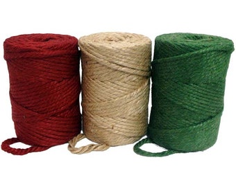 Könnte beinhalten: Drei Spulen mit Garn in den Farben Rot, Natur und Grün. Das Garn ist fest auf den Spulen aufgewickelt.
