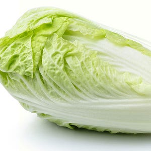 May include: A whole head of light green napa cabbage with white veins, isolated on a white background.