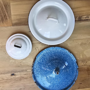 May include: Three enamelware lids, one white with a black rim, one white with a black rim and a handle, and one blue with a black rim.