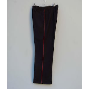 Könnte beinhalten: Schwarze Hose mit einem einzigen roten Streifen in der Mitte jedes Beins.