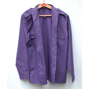 May include: A long-sleeved, purple button-down shirt with two chest pockets and a button-up collar.