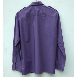 May include: A long-sleeved, purple button-down shirt with a collar.