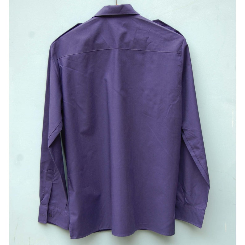 May include: A long-sleeved, purple button-down shirt with a collar.