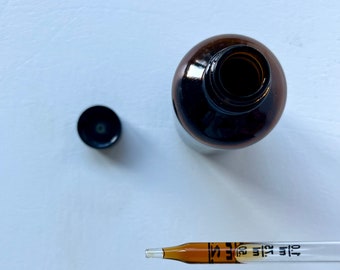 May include: A brown glass bottle with a black cap and a dropper. The dropper is labeled "Dilu Dilu 5".