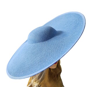 Puede incluir: Un sombrero de sol azul claro con ala ancha y copa redondeada. El sombrero est&aacute; hecho de tela tejida y tiene un dise&ntilde;o simple y elegante. El ala tiene aproximadamente 46 cm de di&aacute;metro.