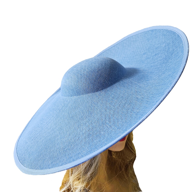 Puede incluir: Un sombrero de sol azul claro con ala ancha y copa redondeada. El sombrero est&aacute; hecho de tela tejida y tiene un dise&ntilde;o simple y elegante. El ala tiene aproximadamente 46 cm de di&aacute;metro.