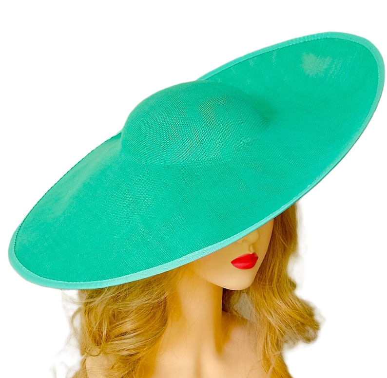 Puede incluir: Un sombrero turquesa de ala ancha con copa redonda. El sombrero tiene una textura tejida y un ribete azul claro. Dise&ntilde;ado para la protecci&oacute;n solar y la moda. El di&aacute;metro del ala es de unos 40 cm.