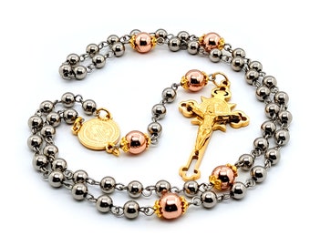 Saint Benedict stainless steel rosary beads with rose gold hematite gemstones and etched gold plated Saint Benedict crucifix.