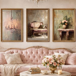 May include: Three framed vintage-style paintings with gold frames. The paintings depict a chandelier, a chair, and a vase of flowers. A pink tufted sofa with pillows and a coffee table with a floral arrangement are in front of the paintings.
