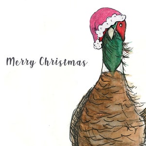 Puede incluir: Una ilustraci&oacute;n de acuarela de un fais&aacute;n con un gorro de Pap&aacute; Noel rosa con ribete blanco. El fais&aacute;n est&aacute; mirando hacia la derecha y el texto "Merry Christmas" est&aacute; escrito en cursiva gris en el lado izquierdo de la imagen.