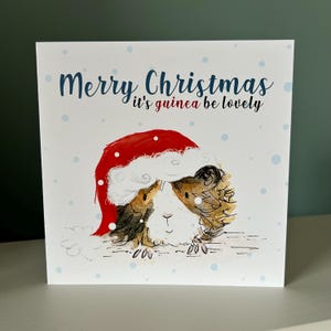 Carte de Noël illustrée de GUINEA be beautiful Christmas Catherine Redgate, lunatique original et original, bonnet de noel, cochon d'inde, cochons mignons, hamster, jeu de mots