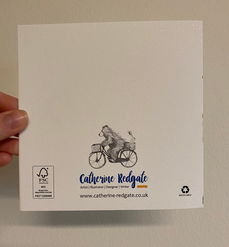 Puede incluir: Una tarjeta blanca con una ilustraci&oacute;n en blanco y negro de un oso montando una bicicleta con un conejo en la cesta. La tarjeta tiene el texto "Catherine Redgate" y "Artist | Illustrator | Designer | Writer" y la direcci&oacute;n del sitio web "www.catherine-redgate.co.uk". La tarjeta tambi&eacute;n tiene el logotipo de FSC y el texto "RECYCLABLE".