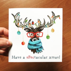 Carte illustrée de Noël spectaculaire Catherine Redgate humour amusant lunatique original mignon jeu de mots drôle tête de cerf bois lumières Noël