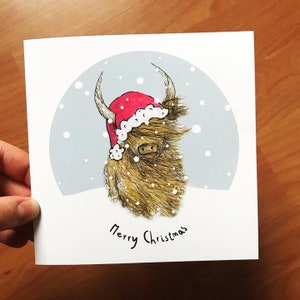 Carte illustrée de COO de NOL Catherine Redgate humour amusant lunatique original mignon vache des Highlands Noël neige Ecosse