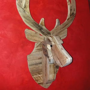 Trophy head of decorative deer in wood
