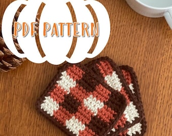 May include: Three crocheted pumpkin-shaped coasters in brown, orange, and white. The coasters are stacked on top of each other. The image includes the text "PDF PATTERN".
