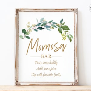 May include: A printable sign with a gold frame and a watercolor illustration of greenery. The sign says "Mimosa Bar" and includes instructions for making mimosas: "Pour some bubbly, Add some juice, Top with favorite fruits".