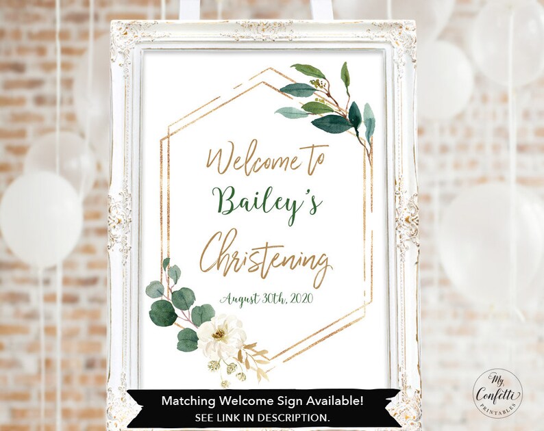 May include: A white framed sign with gold geometric shapes and green foliage. The text on the sign reads "Welcome to Bailey's Christening August 30th, 2020". The sign also includes the text "Matching Welcome Sign Available! SEE LINK IN DESCRIPTION."