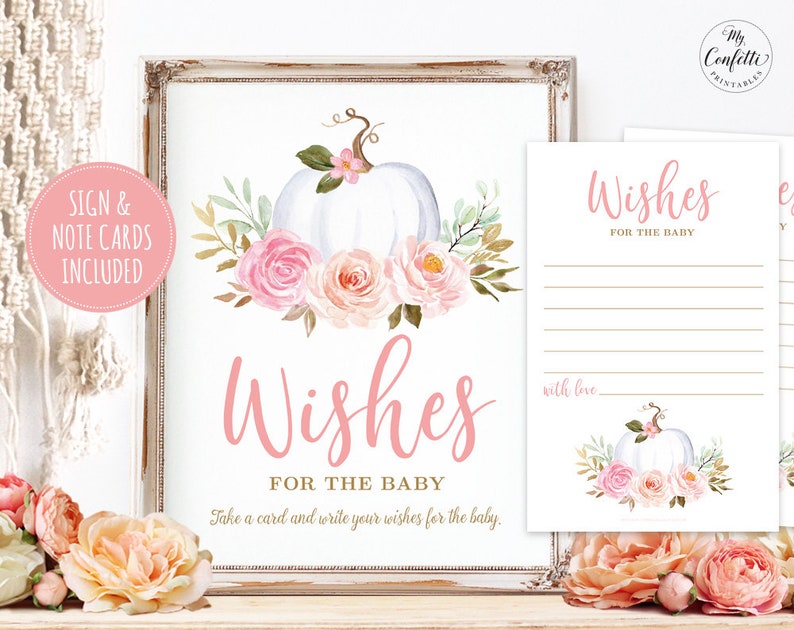 May include: A printable sign for a baby shower with a white pumpkin and pink flowers. The sign says "Wishes for the Baby" and includes instructions to take a card and write wishes for the baby. The sign is framed in a rustic white frame.