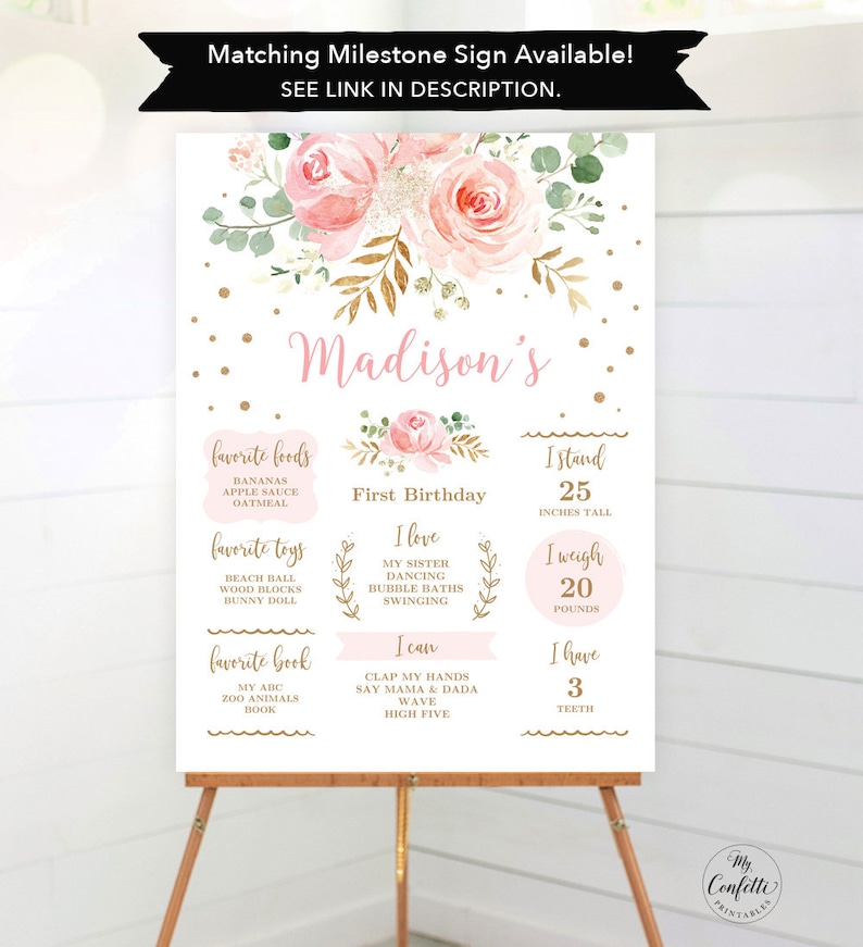 May include: A milestone sign for a first birthday, featuring a floral design with pink roses and gold accents. The sign includes the name "Madison's", favorite foods, toys, and book, along with height (25 inches), weight (20 pounds), and number of teeth (3).