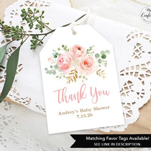 Puede incluir: Una etiqueta de agradecimiento blanca con ilustraciones florales rosas y doradas. El texto dice "Gracias" en letra cursiva rosa, "Baby Shower de Audrey" en rosa m&aacute;s peque&ntilde;o y "7.15.20" en rosa m&aacute;s peque&ntilde;o. La parte inferior de la etiqueta dice "Etiquetas de regalo a juego disponibles! VER ENLACE EN LA DESCRIPCI&Oacute;N."