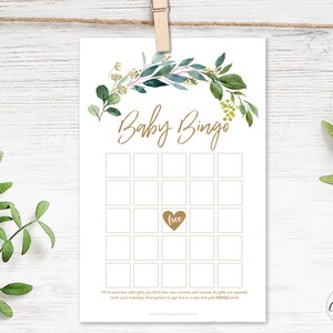 May include: A printable baby bingo card with a green and gold floral border. The card has a 5x5 grid with squares for guests to fill in with gifts they think the new mom will receive. The center square says "free".
