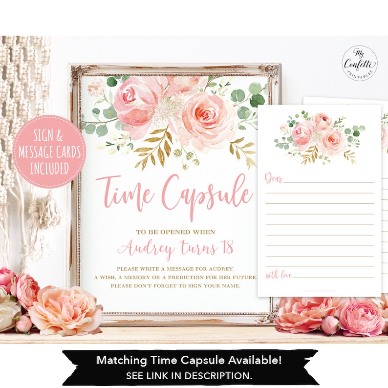 May include: A framed sign and message cards with a floral design. The sign reads "Time Capsule" and includes instructions for writing a message for Audrey. The design features pink roses and greenery. The message cards have a similar floral design.