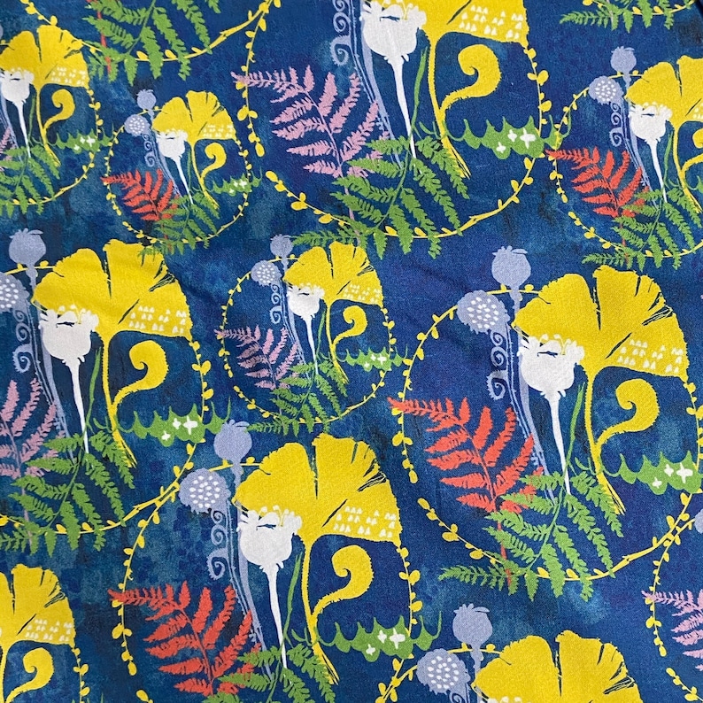 Peut inclure: Un tissu bleu avec un motif r&eacute;p&eacute;titif de fleurs jaunes, de feuilles vertes et de formes de foug&egrave;res roses et rouges.