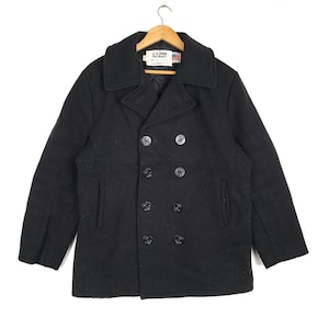 May include: A black peacoat with a double-breasted closure and six buttons. The coat has a label that reads "U.S. N. PEA JACKET".