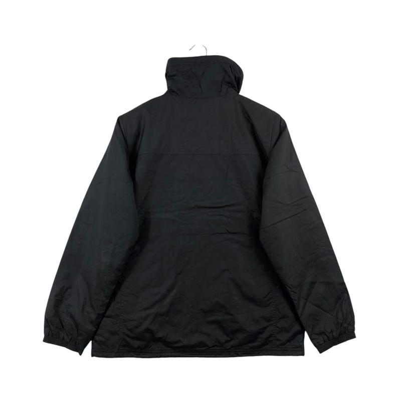 May include: A black jacket with a high collar, hanging from a white hook. The jacket has a simple design with a smooth, matte finish. The back view shows the full length of the jacket, with long sleeves and a straight hemline.
