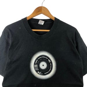 May include: Black t-shirt with a white graphic of a record with the text "Various Artists from Bristol -  1995 -  Full &  A  Winter Collection -  Indus  1"
