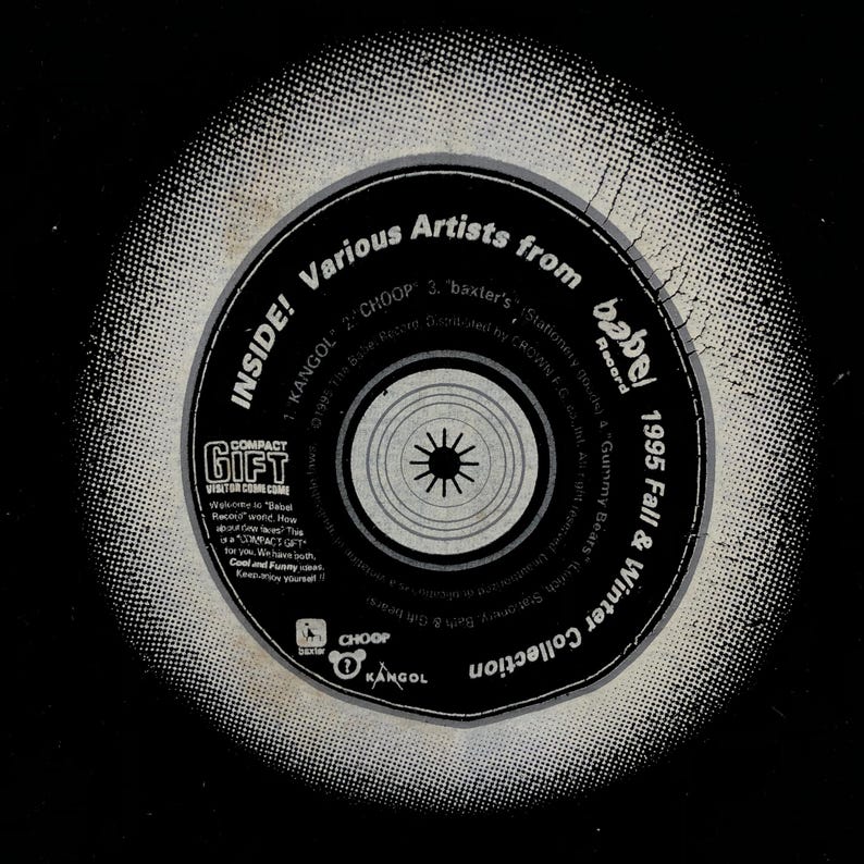 May include: A black and white compact disc with a circular design in the center. The disc has text that reads "INSIDE! Various Artists from babel 1995 Fall & Winter Collection" and "COMPACT GIFT VISITOR COME COME".