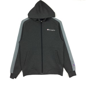 May include: A gray Champion zip-up hoodie with gray and white striped sleeves. The hoodie has a small Champion logo on the left sleeve and the word "Champion" embroidered on the chest.