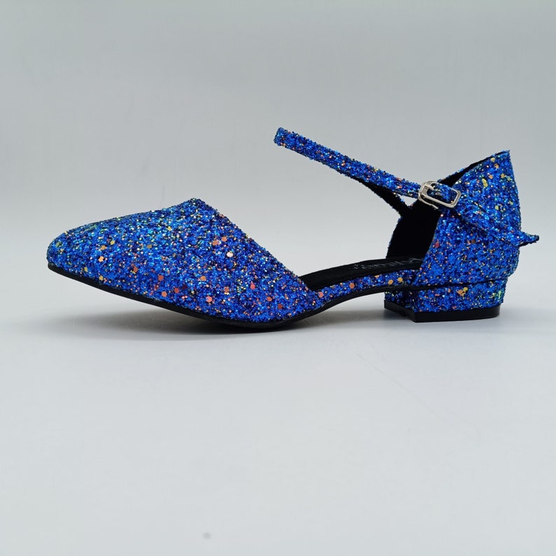 May include: Blue glitter heeled shoes with an ankle strap and buckle fastening.