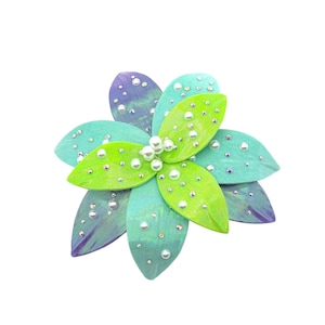 May include: A green and blue flower-shaped brooch with pearl and rhinestone accents.