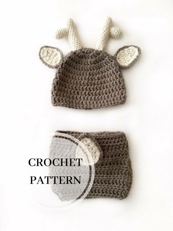 Together in wool cap and mittens baby reindeer and small dog carry by hand crochet
