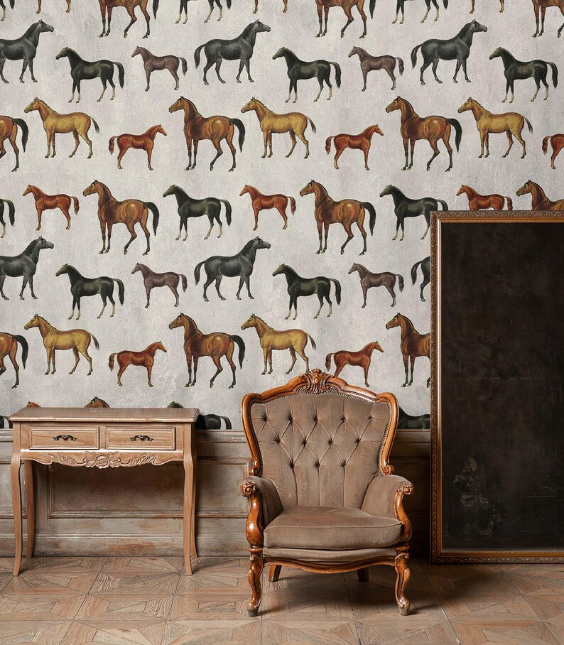 May include: Wallpaper featuring a repeating pattern of horses in various shades of brown, black, and tan against a light gray background. A wooden console table with two drawers and a tufted brown armchair are positioned in front of the wall.