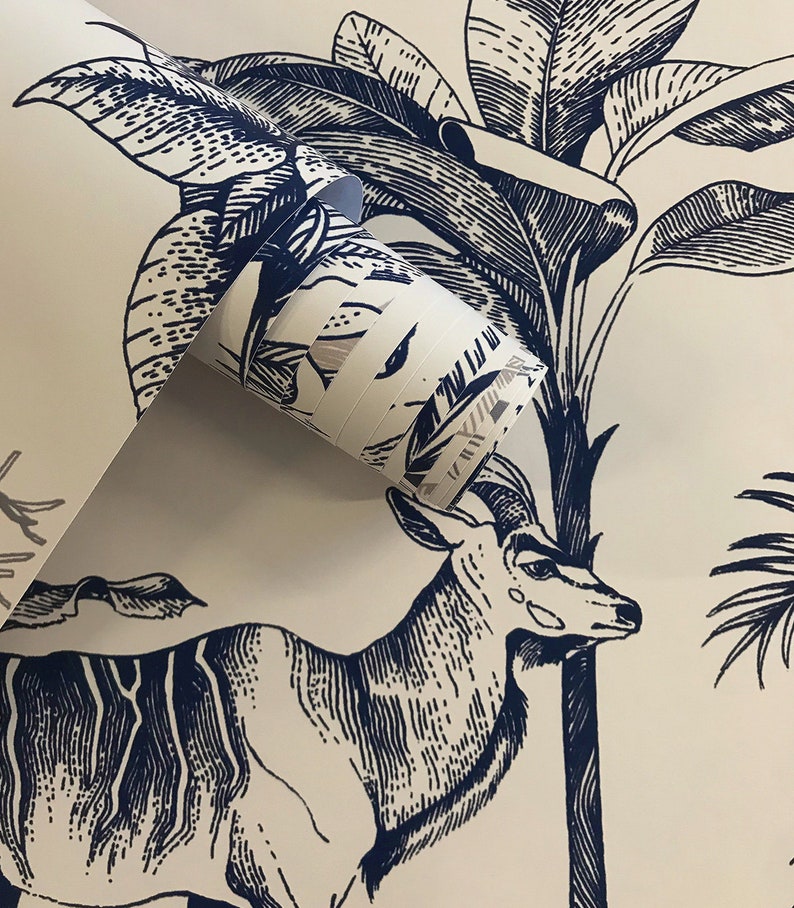 May include: A roll of wallpaper featuring a dark blue ink illustration on a cream background. The design depicts a detailed antelope standing among large tropical palm leaves and foliage, rendered in a classic etched or woodcut style.