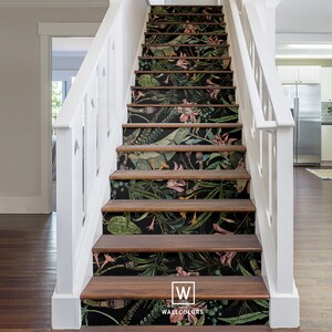 May include: A set of stairs with a dark green and pink floral wallpaper design. The wallpaper features large leaves, flowers, and vines. The stairs are made of wood and have a white railing. The text "W WALLCOLORS" is visible at the bottom of the image.