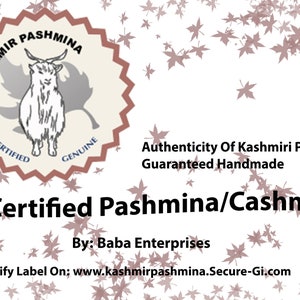 May include: A white background with a brown and white seal featuring a goat and the text "Kashmir Pashmina Certified Genuine". The text "Authenticity of Kashmiri Pashmina Guaranteed Handmade" is below the seal. The text "GI Certified Pashmina/Cashmere" is below the text. The text "By: Baba Enterprises" is below the text. The text "Verify Label On: www.kashmirpashmina.Secure-Gi.com" is below the text. The background is decorated with brown maple leaves.