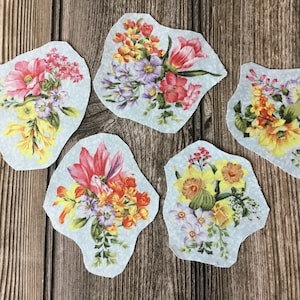 May include: Five floral fabric patches with a light blue background. The patches feature different floral arrangements with pink, yellow, and red flowers.
