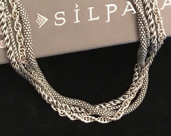 May include: A silver multi-strand necklace with a variety of chain styles. The necklace is on a gray background with the word "SILPA" printed on it.