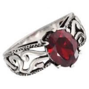 May include: A silver ring with an ornate design and a large, red gemstone.