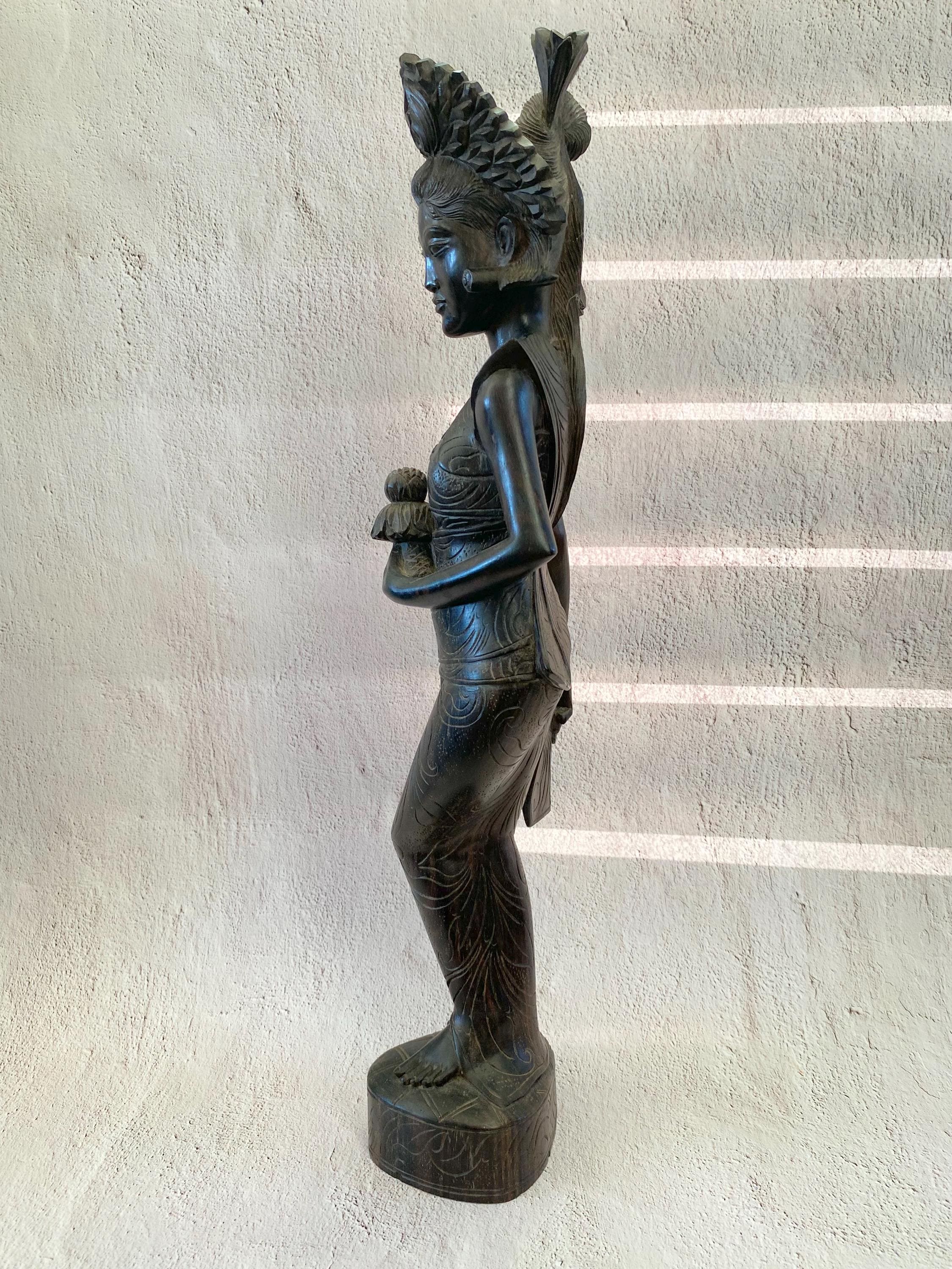 バリ島の手彫りの木彫像 - 蓮の花を持つ女性の木彫像 - 祭壇に供物を