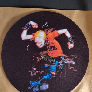 May include: A black felt turntable slipmat with a cartoon illustration of a person wearing a red shirt with the text "Circle Jerks" printed on it. The person is wearing blue jeans, black boots, and a chain around their waist.
