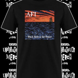 May include: Black t-shirt featuring the band name "AFI" above a graphic of a ship sailing on a wavy sea under a sunset. The text "Black Sails in the Sunset" is below the graphic. The shirt has the website "www.undergroundmerch.com" printed on it.