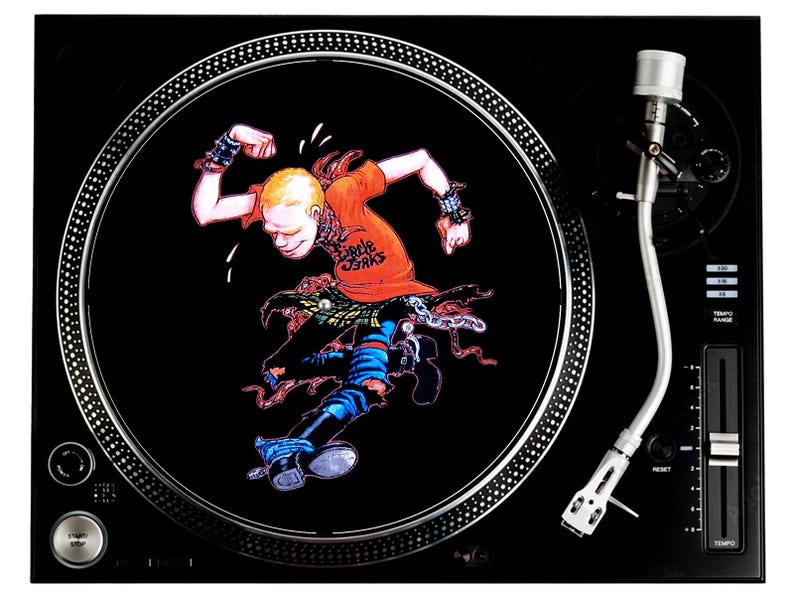 May include: A black turntable with a silver tone arm and a circular slipmat featuring a cartoon illustration of a person in a red shirt with the text "Circle Jerks" on it.